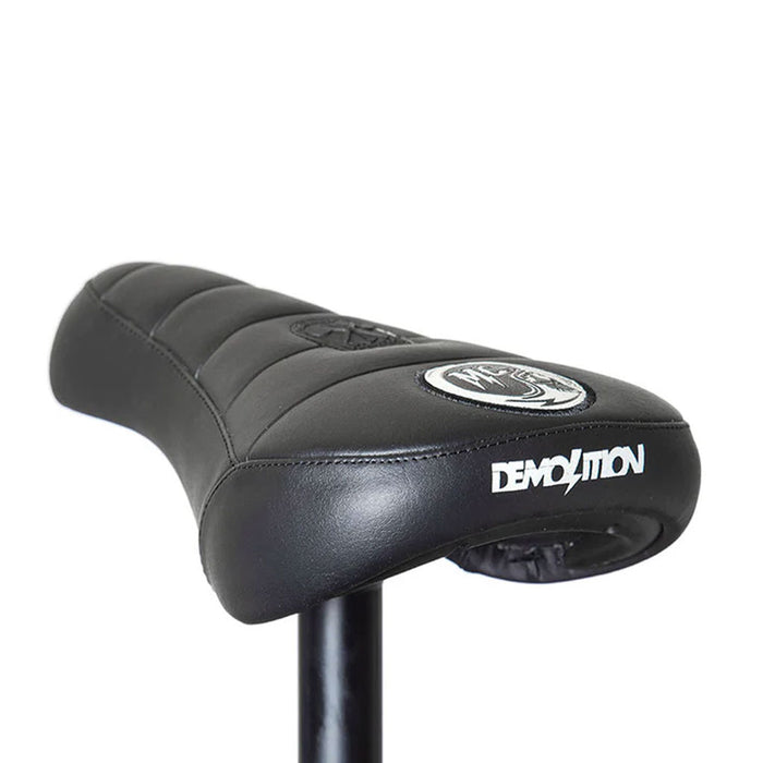 Close-up of the Demolition Matt Cordova Seat (V1) in black, featuring the "Demolition" branding on the back. This Pivotal Fat Cap design, perfect for BMX enthusiasts, offers both comfort and style for any ride.