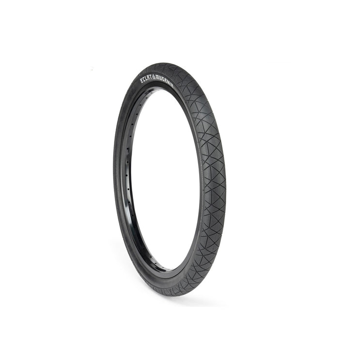 The ECLAT Mugen Flatland Tyre, known for its high performance on flatland terrains, showcases a textured tread pattern and is displayed upright against a white background.