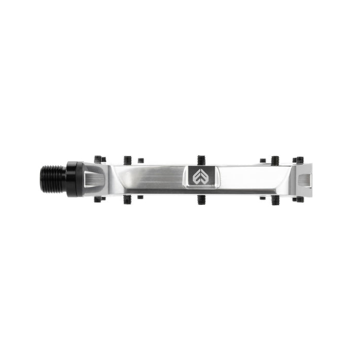 The Eclat Surge XL Pedal boasts a metallic rectangular design with an oversize platform area, complete with black screws and a black threaded spindle on one side. It features a logo with an upward-pointing arrow and incorporates a dual bearing/bushing spindle system for superior performance.