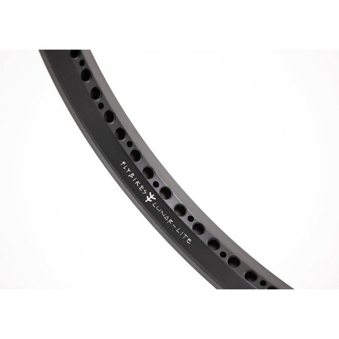 Close-up of the Fly Bikes Lunar Lite Rim, a black front wheel rim featuring multiple holes and "FLYKEST LUNAR-LITE" in white, highlighting its sleek design.