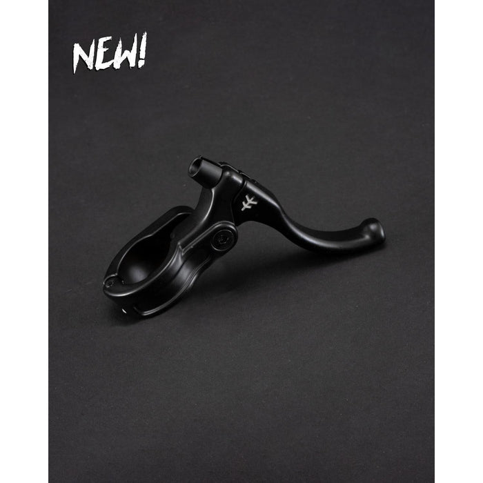 The Fly Bikes Manual Lever Mini, in black, is showcased on a dark backdrop with CNC brass bushings for precision braking. "NEW!" lights up the top left corner, highlighting this state-of-the-art addition to the collection.