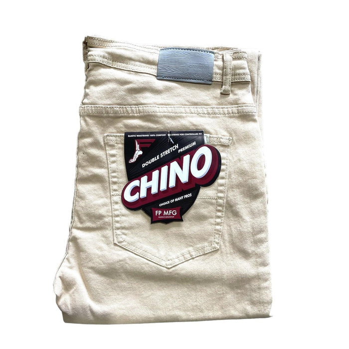 A pair of beige chino pants folded neatly, with a label on the back pocket that reads "Double Stretch Premium Chino, FP MFG." These FP Pants Relaxed Fit Chino Bone are designed with skate enthusiasts in mind.