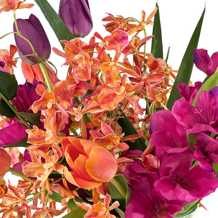 Bouquet of colorful mixed Faux flowers including tulips, gladiolus and orchids on a white background