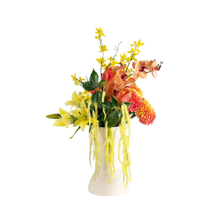 Faux Floral arrangement with yellow and orange flowers in a off white vase on a white background