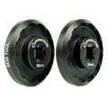 Installing a pair of black wheels using the Praxis Works M30 Standard Bottom Bracket Tool on a white background.