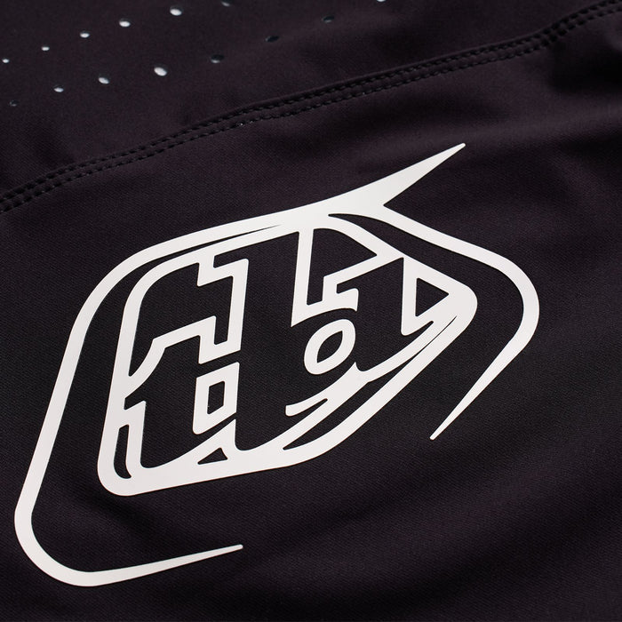 The TLD 25.1 Youth Sprint Pant Mono Black is crafted from durable material and features a white logo with stylized text and geometric accents.